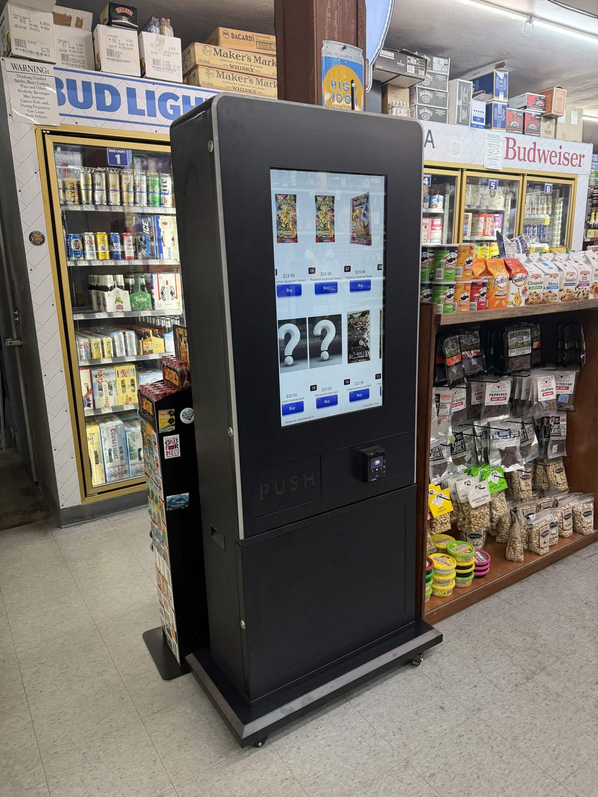 A card vending machine placed between coolers in a busy liquor store